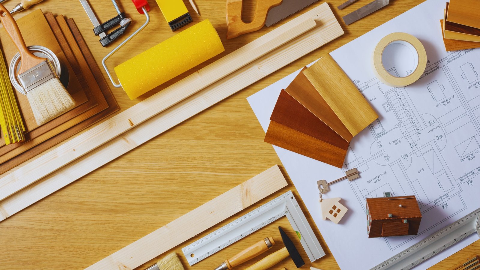 Tools, wood samples, and project materials laid out for planning a building remodel or repair.